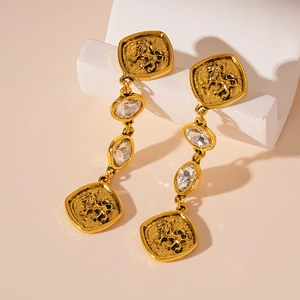Détail de boucles d'oreilles lion vintage dorées avec cristaux et pendants à franges