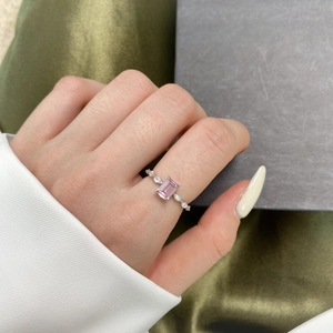 Detailed close-up of a silver ring with a pink rectangular gemstone and small diamonds