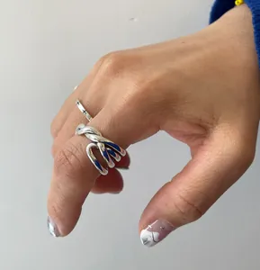 Detailed view of silver 925 irregular crossover ring with deep blue enamel inlay accents