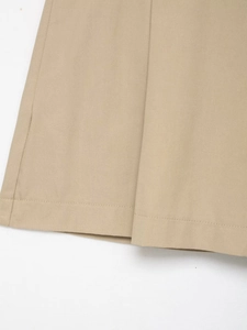Detailed close-up of khaki twill fabric texture and neat stitching on shorts hemline