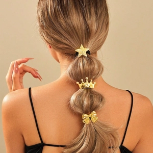 Three-piece gold metal hair set with star, crown, and bow designs on a braided hairstyle