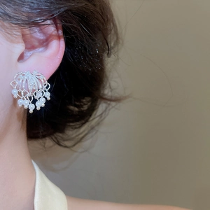Detailed close-up of elegant firework-style pearl ear clips with silver finish on model