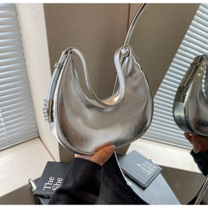 Detailed close-up of a silver crescent moon hobo bag with reflective mirror finish