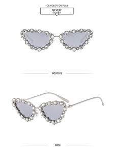 Detail of silver cat eye sunglasses frame with dense rhinestone inlay and grey lenses