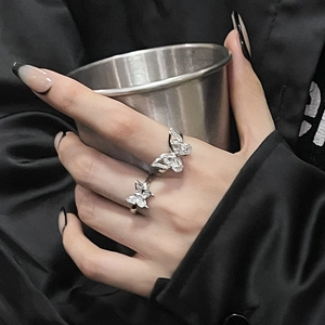Detailed close-up of a silver butterfly ring with cubic zirconia on a model's finger