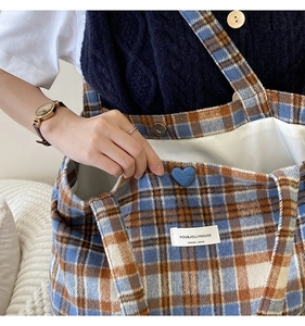 Détail du sac cabas rétro à carreaux avec bouton en cœur et étiquette tissée