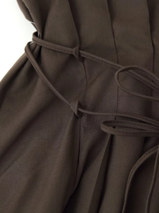 Detail view of the drawstring waist on a dark brown maxi dress with linen texture