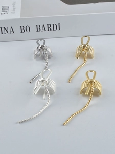 Detailed view of gold and silver tassel ear clips in a cage design with rope chains