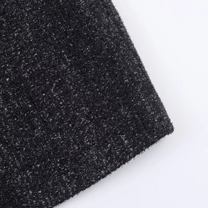 Detailaufnahme von schwarzem Tweed-Stoff mit glänzenden metallischen Silberfäden-Effekten