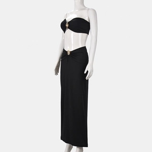Detail of black two-piece bodycon maxi dress with metallic gold rings and side cutout