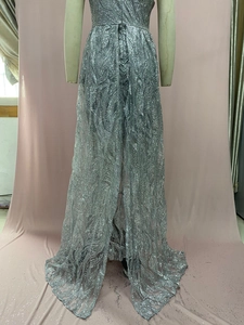Detail eines silbernen Pailletten-Abendkleids mit Reißverschluss am Rücken und Wellenmuster