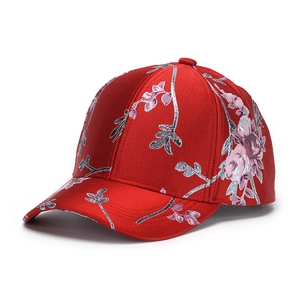 Detail of red satin baseball cap with intricate pink and silver floral embroidery