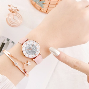 Detail van strass horloge met roze lederen band en ster hanger armband voor dames