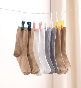 Detail of four pairs of ribbed cotton blend socks hanging on a drying line with clips