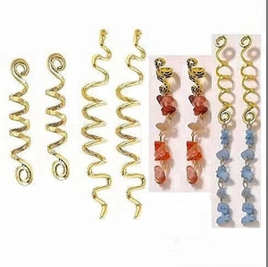 Detail of gold spiral hair rings and ethnic beads for dreadlocks styling accessories