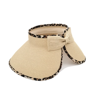 Detail view of straw sun hat with leopard trim and large decorative back bow