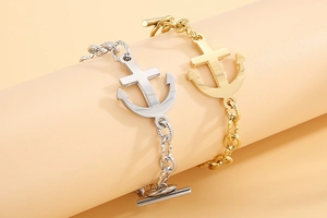 Detailed close-up of gold and silver anchor bracelets with toggle clasps and polished finish