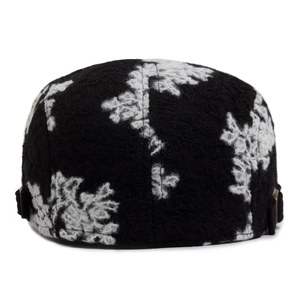 Rear view of vintage black and white jacquard beret hat with fuzzy texture and metal buckles