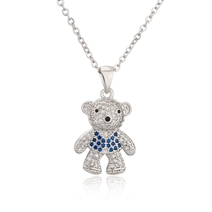 Macro detail of silver teddy bear pendant with sparkling white and blue zircons