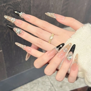 Detailed macro view of long stiletto press-on nails with pink black rhinestones and pearls