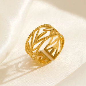 18K gold plated leaf-shaped open ring with intricate hollow texture on silk background
