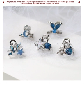 Dettaglio di 5 mini mollette argentate con motivi di stelle marine e sirene blu