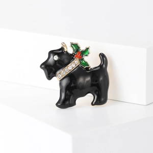 Detailed macro view of black enamel Scottish Terrier brooch with festive red and green rhinestones