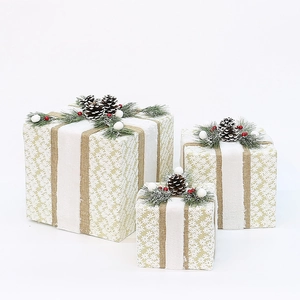 Three-piece gold and white Christmas gift box set with pine cones and snowflakes