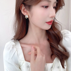 Boucles d'oreilles élégantes en émail perle baroque avec cadre doré sur mannequin chic