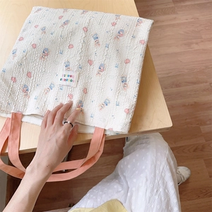 Detailed view of the embossed white canvas fabric featuring cute rabbit and heart patterns