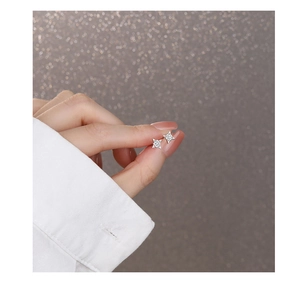 Detailed view of S925 silver star stud earrings with sparkling cubic zirconia held in hand