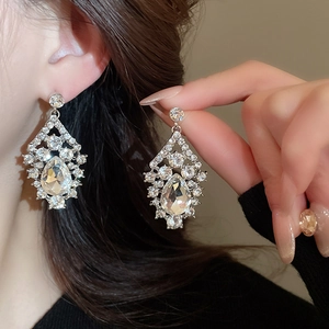 Close-up of silver teardrop earrings with sparkling crystals shown in high detail