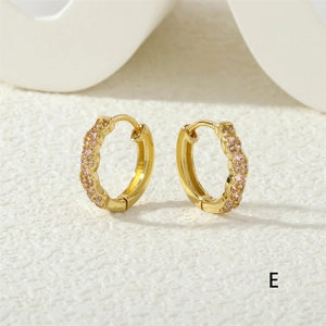 Close-up of golden hoop earrings with two rows of pink zircons and wavy edge design