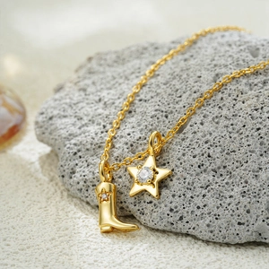 18K gold stainless steel necklace with western boot and horseshoe pendant on rocks