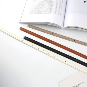 Detail of four colorful minimalist slim leather belts with fine stitching and multiple holes