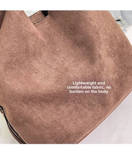 Detailed macro view of soft brown suede texture on this stylish vintage crossbody bag