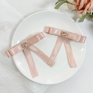 Barrettes à cheveux nbow roses avec cœur en strass sur une assiette blanche