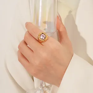 Anello vintage dorato con zircone quadrato rosa indossato sul dito di una donna