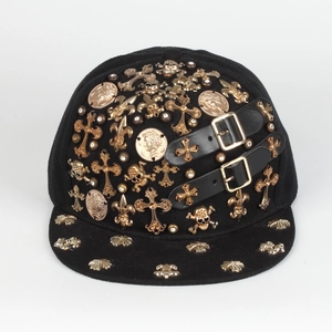 Detail of gothic snapback hat featuring gold skull icons and black leather side straps