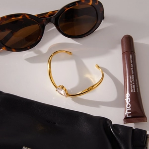 Schicke Lifestyle-Ansicht eines goldenen Wellenarmbands mit birnenförmigem Zirkoniastein
