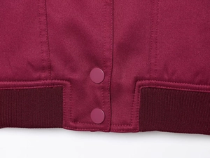 Macro detail of wine red jacket hem featuring twill fabric and ribbed elastic cuffs