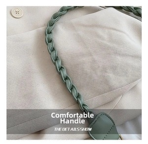 Detailed macro view of green braided leather handbag handle and weave texture