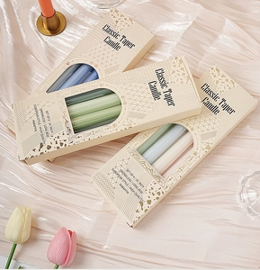 Detalle de velas cónicas de 25cm en colores surtidos y empaque elegante para bodas