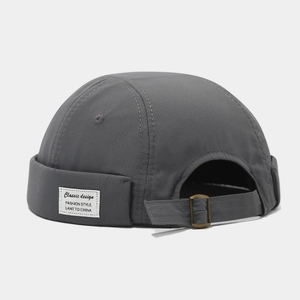 Détail du bonnet Miki gris foncé avec texture ripstop et boucle métallique réglable