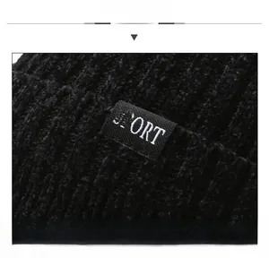 Close-up of black chenille knit beanie texture and SPORT label for men's winter hat