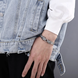 Detail of vintage steel bracelet featuring dual snake head clasp and metal strap
