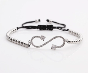 Detail of silver infinity symbol bracelet with zircon stones and adjustable black pull cord