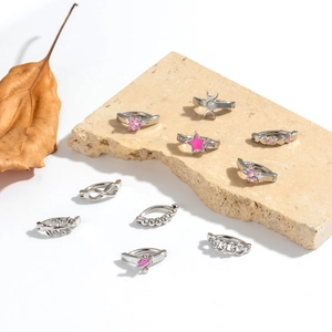 Verschiedene silberne Bauchnabelpiercings mit Herz und Stern auf Steinhintergrund