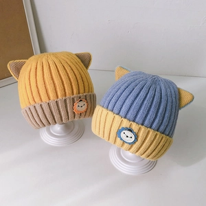 Cute newborn baby knit hats with cat ears in mustard and blue colors on display stands
