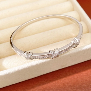 Macro shot of silver plated X-shaped bangle with cubic zirconia in a jewelry box